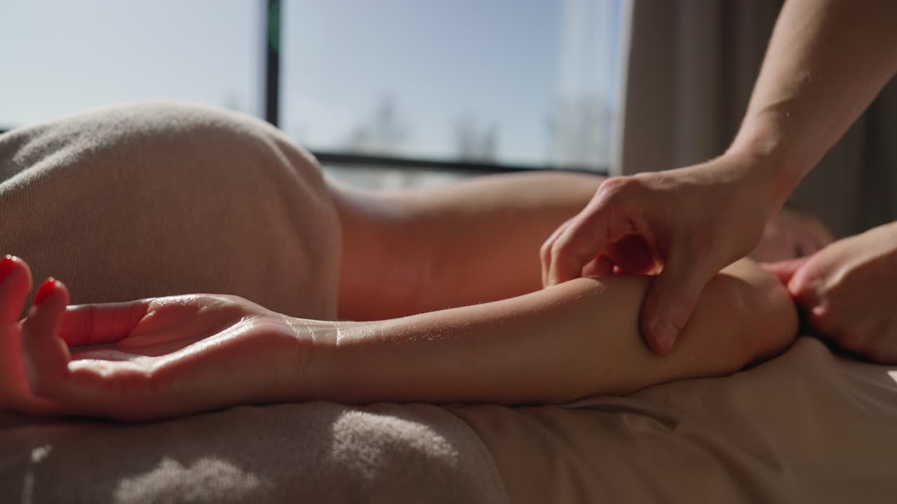 Professionel massør giver armmassage til en kvinde i et spa