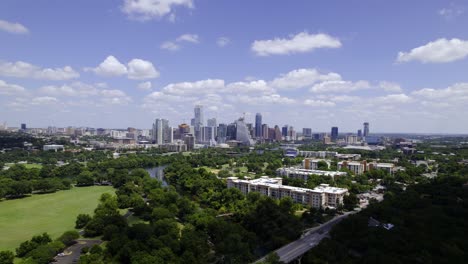 Vista-Aérea-Sobre-El-Parque-Zilker,-Hacia-El-Horizonte-De-Austin-En-El-Soleado-Texas,-Estados-Unidos