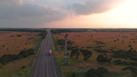 Sunset-Over-The-Country-Road-With-Column-Of-The-Elveden-War-Memorial,-Suffolk,-United-Kingdom