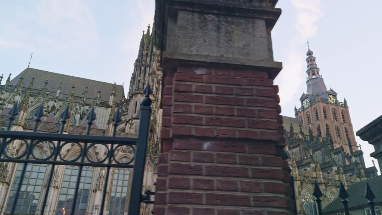 Saint John's Cathedral in 's- Hertogenbosch Den Bosch in Netherlands, view of the building chapel, fence, wall, blue sky and spires, authentic traditional Dutch European architecture style design