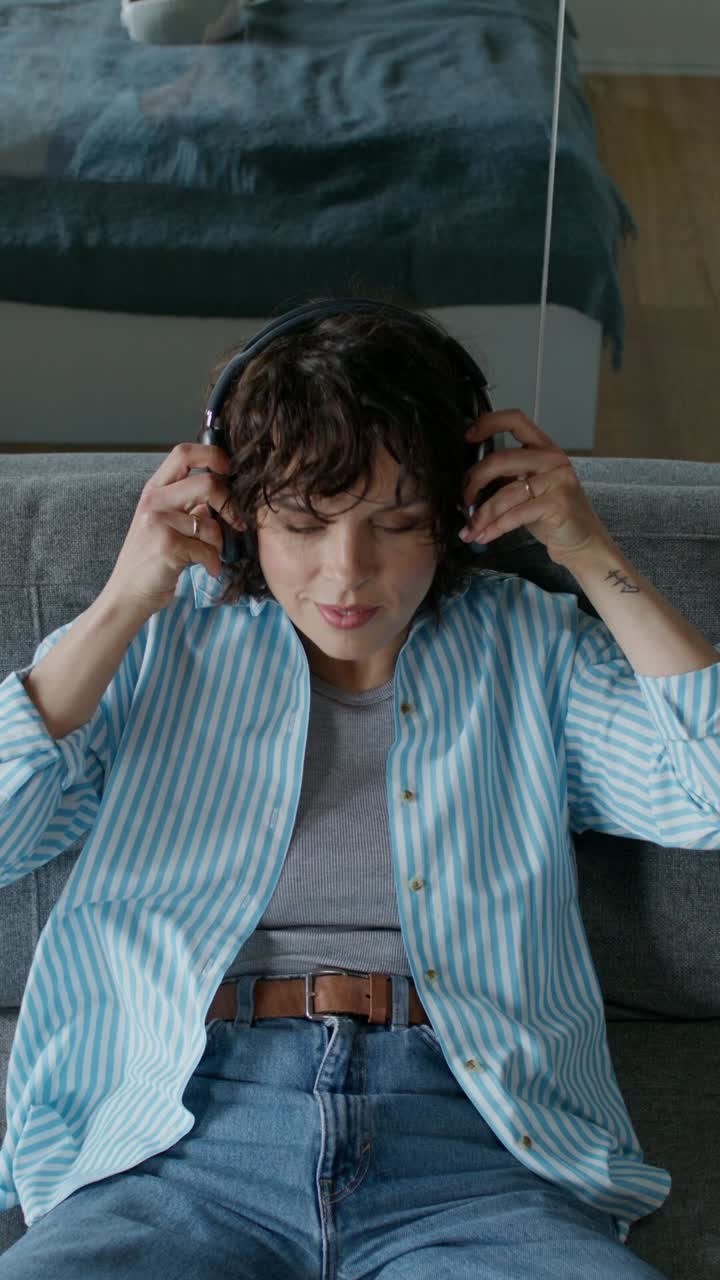 mujer escuchando música en un sofá