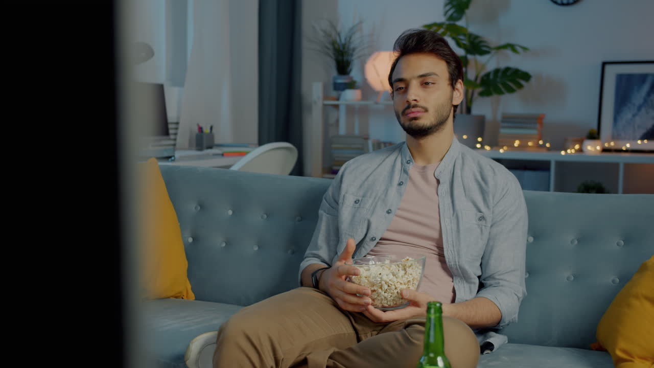 Homem Assistindo TV com Pipoca e Cerveja