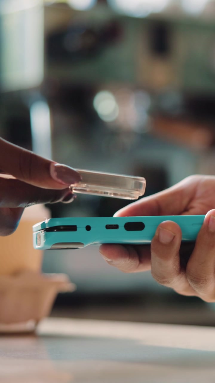 Customer Making Contactless Payment with Smartphone at Cafe Counter