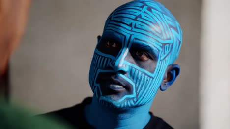 hombre con la cara pintada de azul