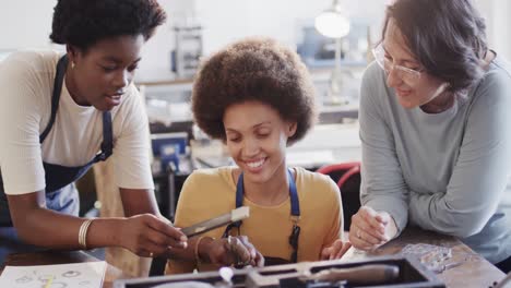 Busy-diverse-female-workers-shaping-ring-with-handcraft-tools-in-studio-in-slow-motion