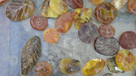 top view shot of scatterd pieces of amber in variuos colours and shapes