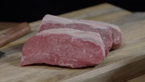 cortes de nueva york, carne sin huesos en la tabla de madera después del corte