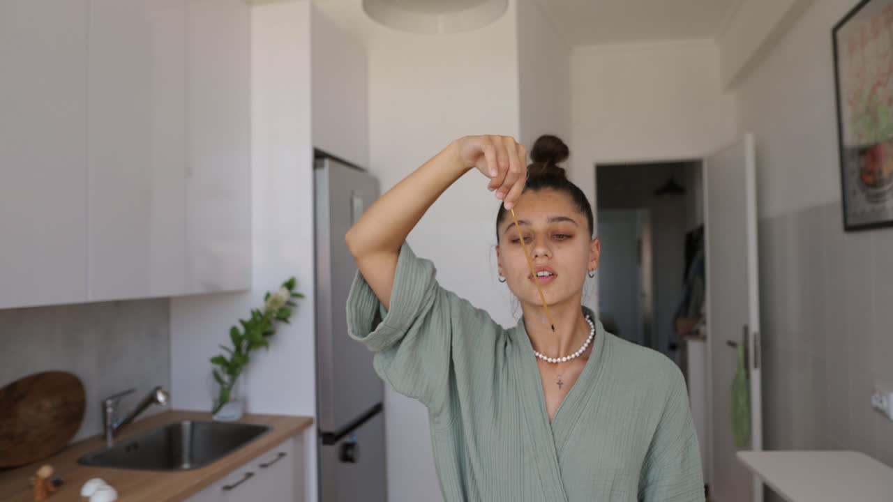 Woman burning incense in a modern kitchen