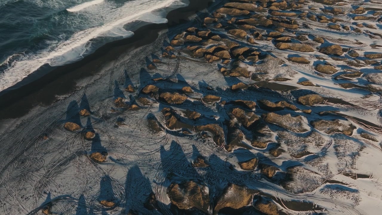 Aerial of Rugged Coastline with Rock Formations and Waves