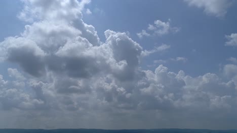 white fuffy clouds with blue sky seen left to right with slow zoom out