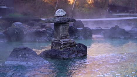 stone pillar inside natural japanese hot spring with steaming hot water