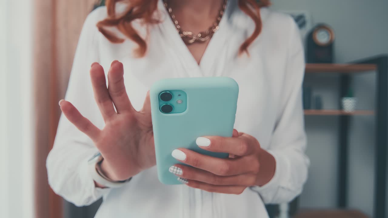 un primer plano de una mujer caucásica sosteniendo un teléfono móvil escribiendo un mensaje usando internet.