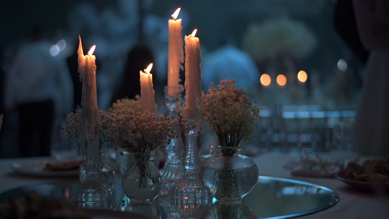 Candele accese vicino a dei fiori durante una festa. Scatto ravvicinato