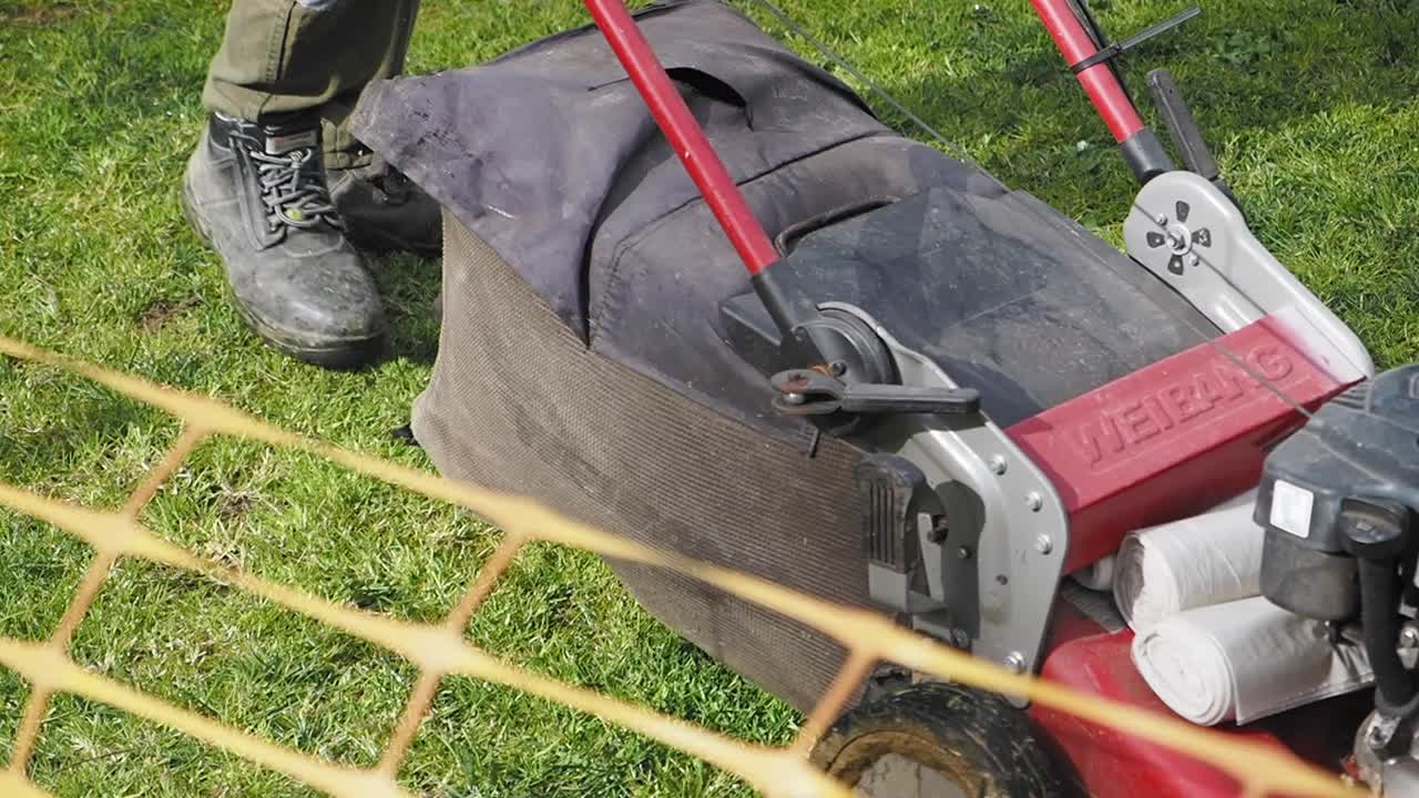 persona cortando el césped con una cortadora de césped