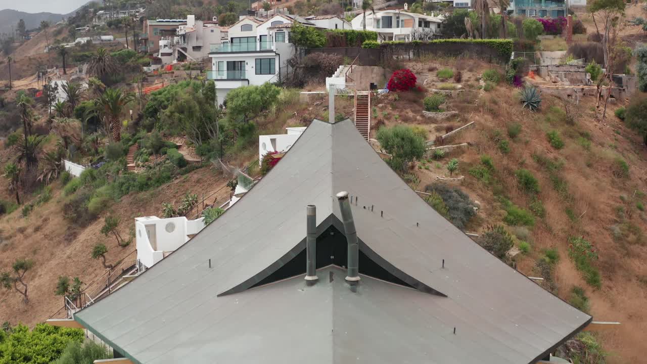 Aerial rising close-up shot of homes on the hillside near Las Flores Canyon that were affected by the Palisades Fire in Malibu, California. 4K