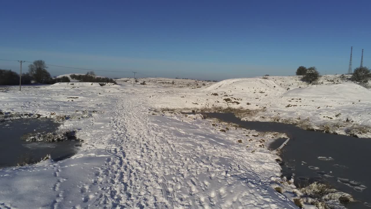 cubierto de nieve rural invierno campo pista huella sombras terreno vista aérea volando entre estanques