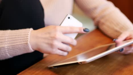 mujer usando tableta digital y teléfono móvil