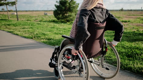 woman in wheelchair on a park path