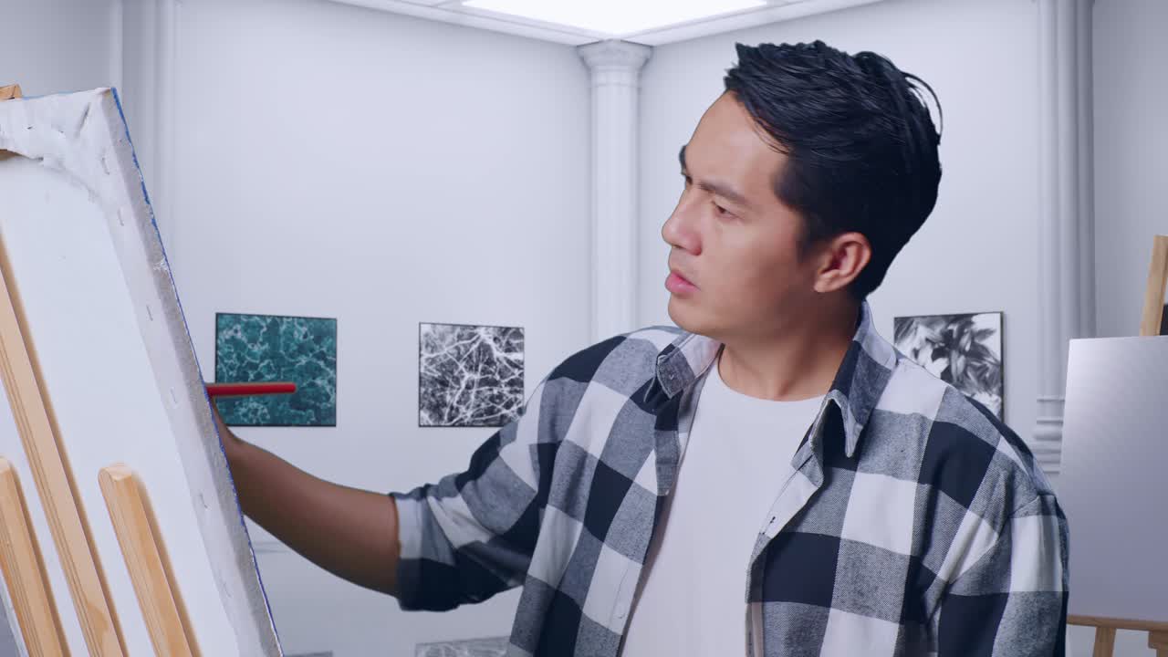 아시아 남성 예술가가 캔버스에 칠하는 동안 영감을 잃었습니다. 갤러리에서 오일 페인트와 으로.