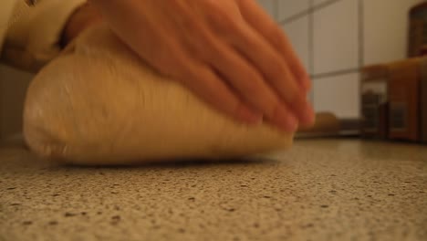 Shaping-a-homemade-loaf-of-sourdough-bread-dough-in-the-kitchen