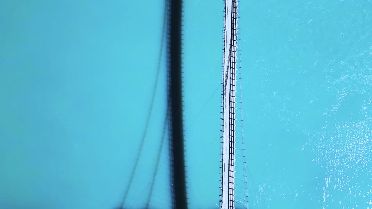 tomada de un avión no tripulado de un puente en movimiento sobre un lago con el reflejo del puente cayendo sobre el agua del lago en skardu, pakistán