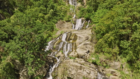 Ella-Sri-Lanka-Aerial-v38-drone-ascending-above-the-Ravana-Waterfall-capturing-breathtaking-views-of-cliffside-jungle,-rock-pool-and-water-cascading-downward---Shot-with-Mavic-3-Cine---April-2023