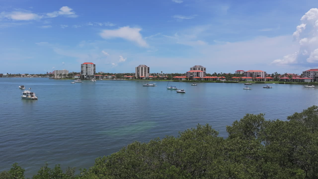 Aerial view of Boca Ciera Bay in St. Petersburg, FL showcasing a peaceful lagoon with sailboats and modern condos —coastal living at its finest
