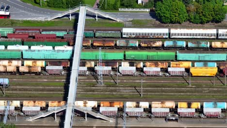 Vista-Aérea-De-Vagones-De-Tren-Y-Camiones-Cisterna-De-Diversos-Usos-Que-Se-Encuentran-En-La-Estación-De-Tren.