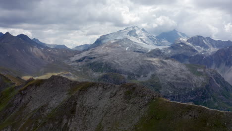 drone mountain view around tignes, flying over a ridge with la grande motte glacier on the back