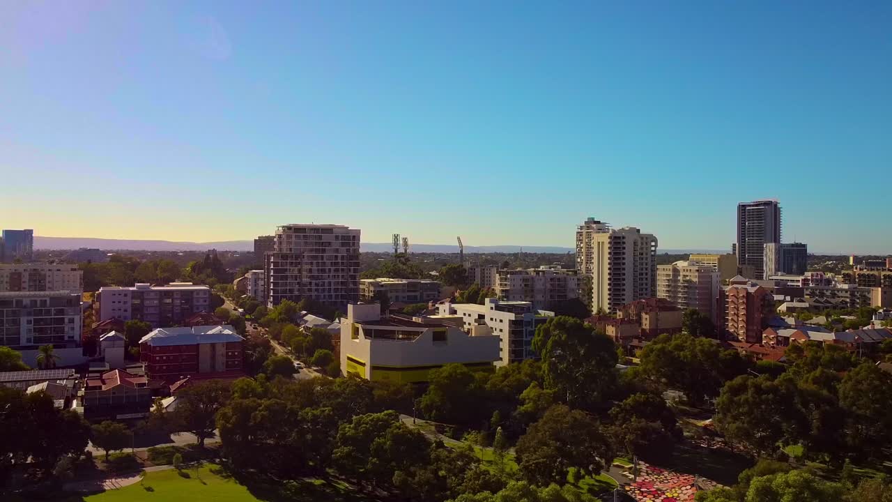 hermoso amanecer aéreo sobre east perth edificios de apartamentos y parque con colinas en la distancia
