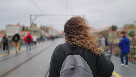 vrouw loopt op een stadsbrug.