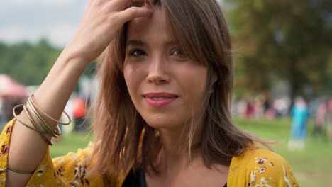 Close-up-of-caucasian-woman-walking-and-turning-to-camera-side-at-music-festival.