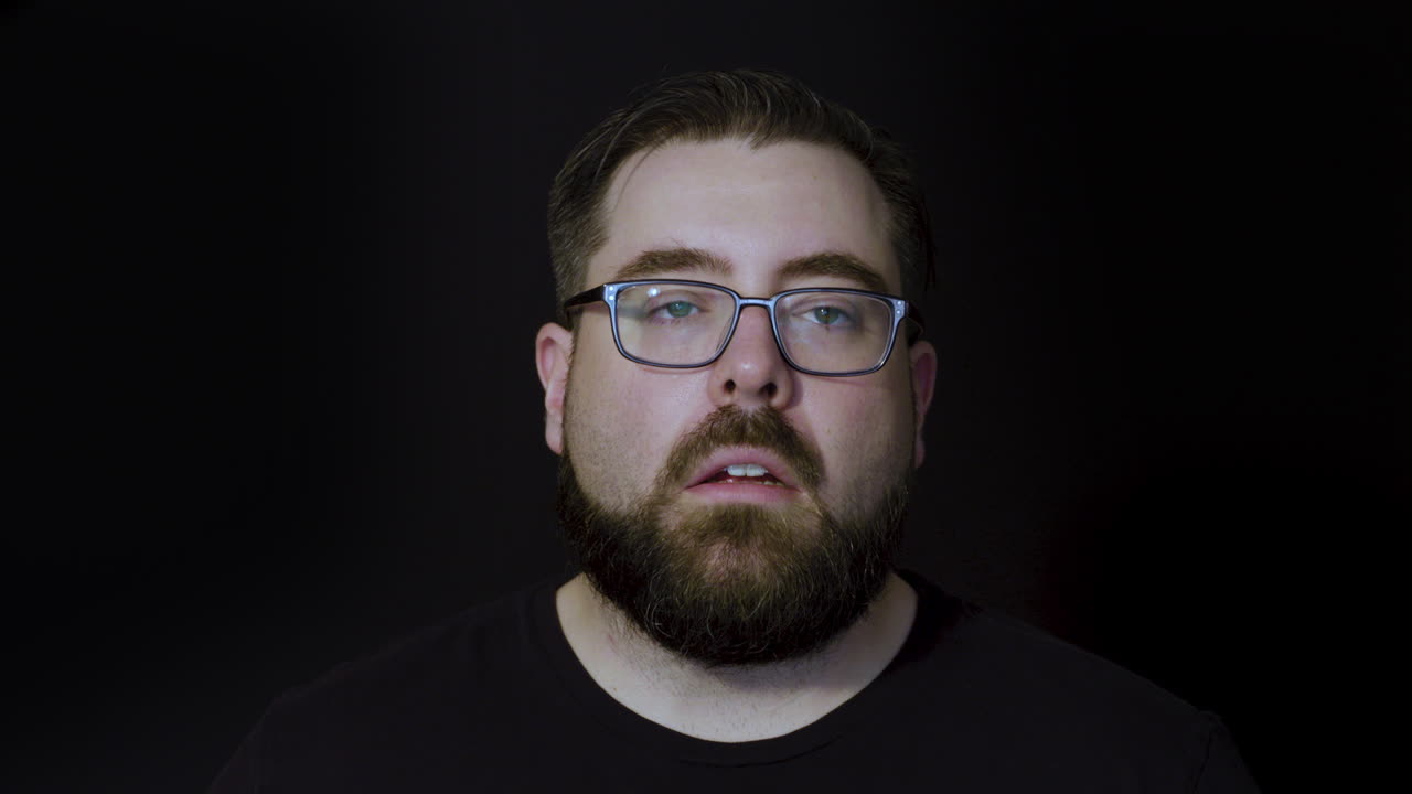 retrato de estudio de movimiento de un hombre barbudo que expresa conmoción y miedo