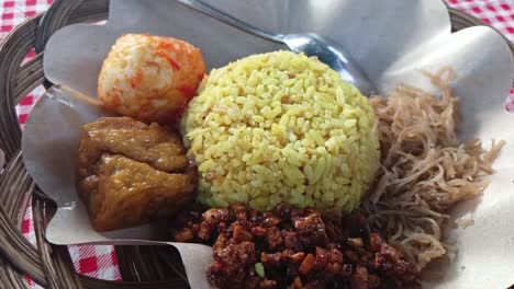 Indonesian-yellow-rice-served-with-tofu,-egg,-vermicelli-and-orek-tempe