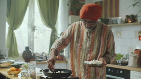 indian food blogger teaching how to cook pan-fried cheese in kitchen