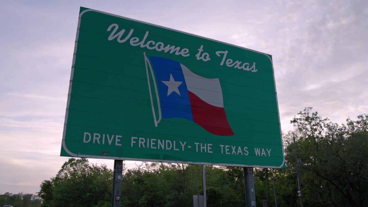 bienvenidos a texas. conduce amigablemente el signo de camino de texas en la línea estatal con video gimbal estable.