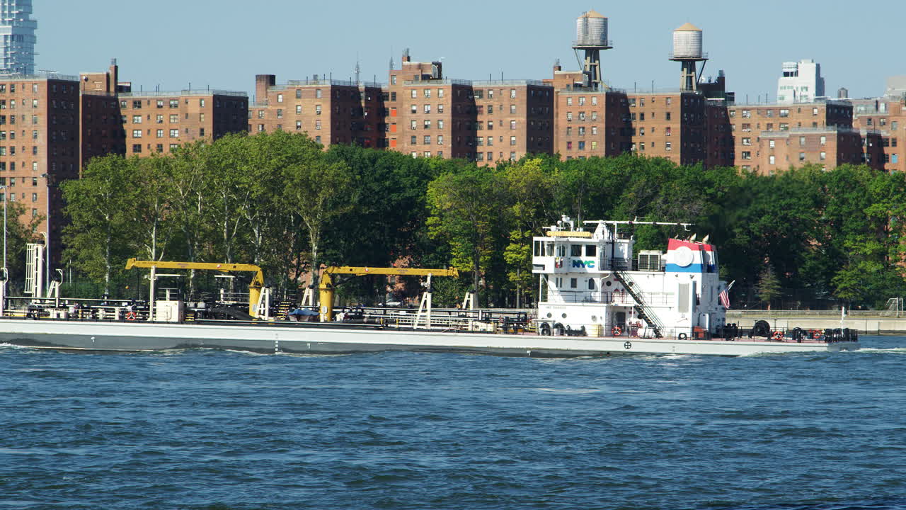 barco de carga en el río hudson con el horizonte de manhattan en el fondo