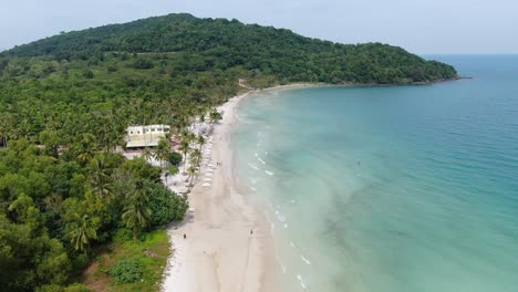 Drone-aerial-view-in-Vietnam-flying-over-Phu-Quoc-island-Sao-beach,-white-sand,-crystal-clear-blue-turquoise-water,-green-palm-trees-forest-and-people-walking-on-a-sunny-day