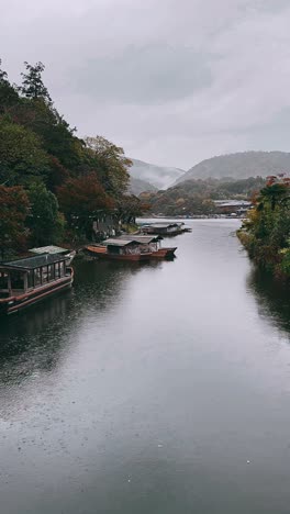 rainy autumn scenery along a japanese river with traditional boats