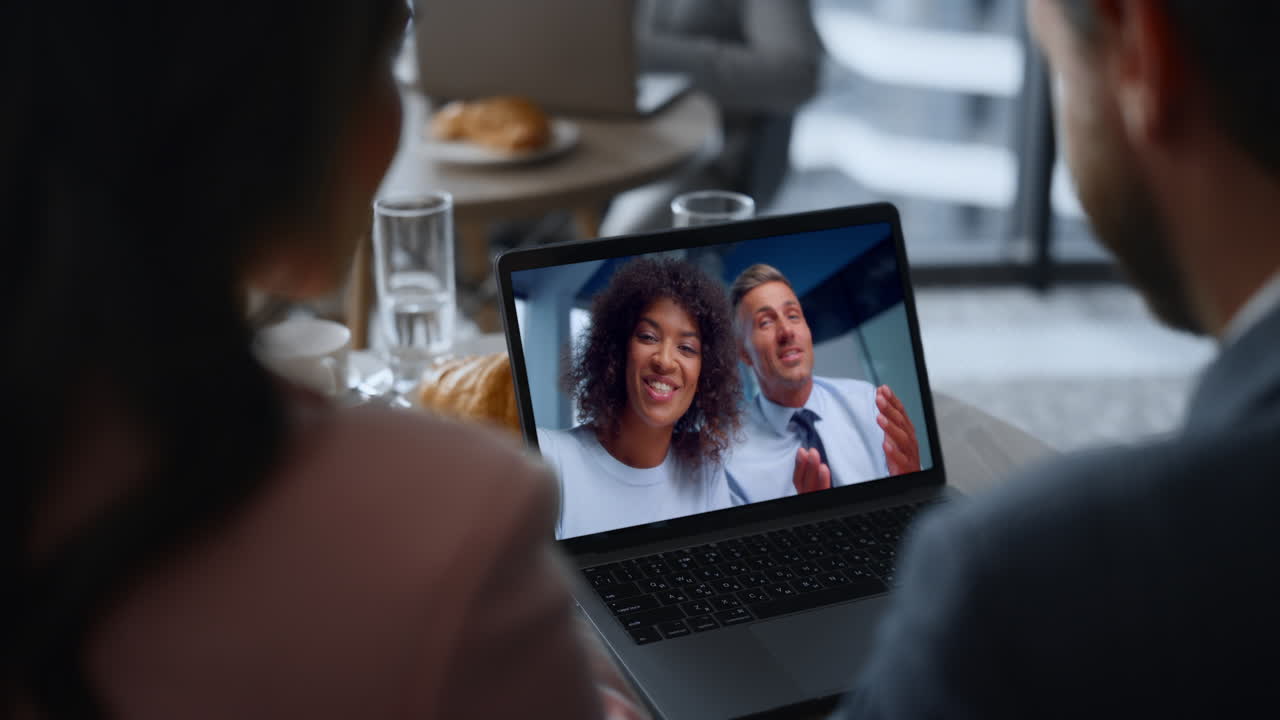 Business team calling laptop having friendly work conversation in cafe close up