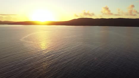 Aerial flying above sea off Sant&#039;Antioco coast in Sardinia, beautiful sunset