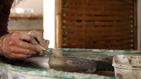 mid section of potter making pot