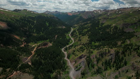 aerial cinematic drone summer million dollar highway red mountain pass silverton ouray telluride afternoon green lush wildflowers windy car road high altitude scenic view 14er forward up reveal