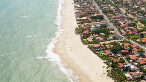 Vista-Aérea-Del-Mar,-Las-Olas-Y-La-Ciudad-Alrededor,-Cumbuco,-Ceará,-Brasil