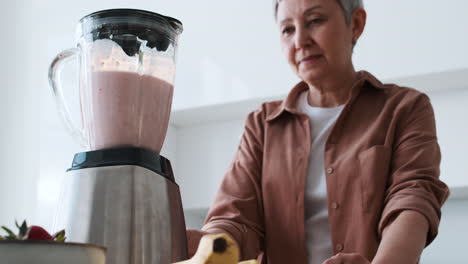 una mujer haciendo un batido.