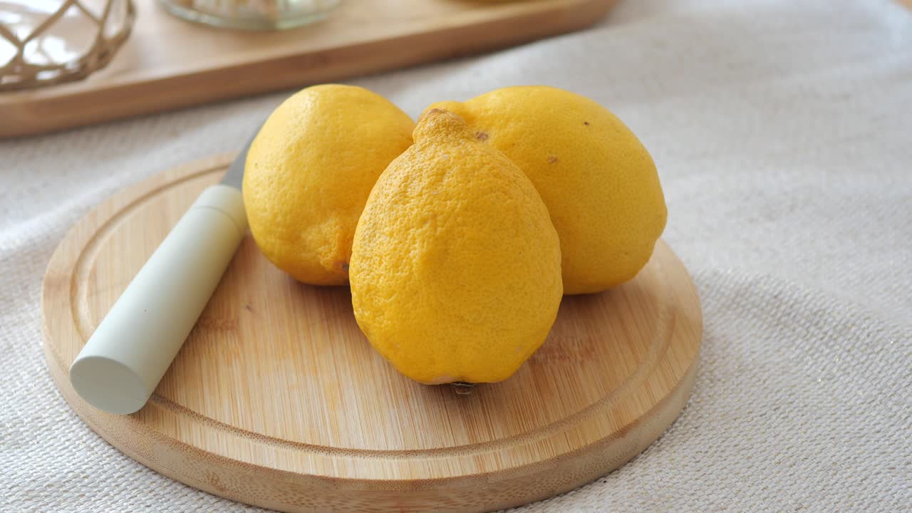 Lemons on a wooden board with knife