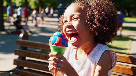 happy young girl enjoying a colorful snow cone in a park