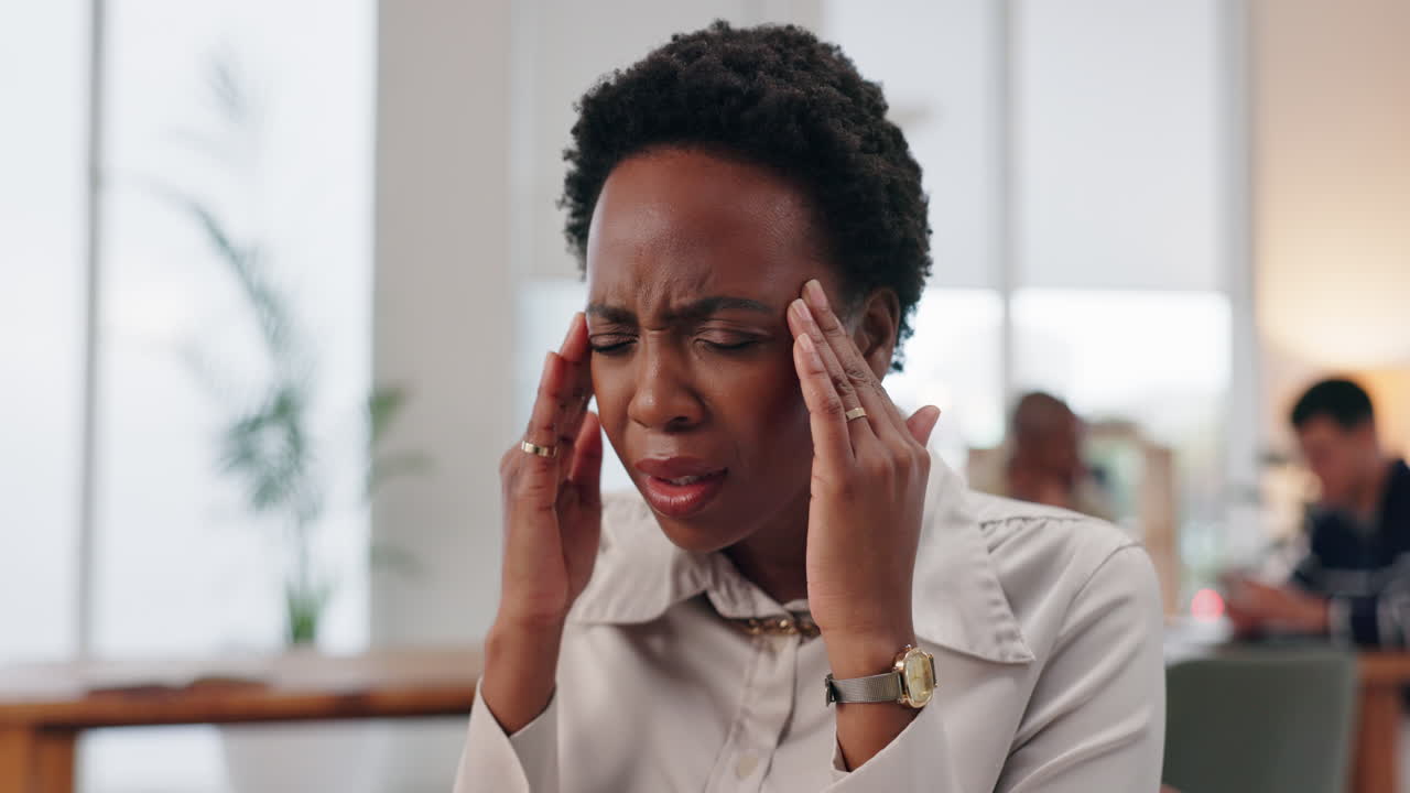 Stressed woman with headache at the office