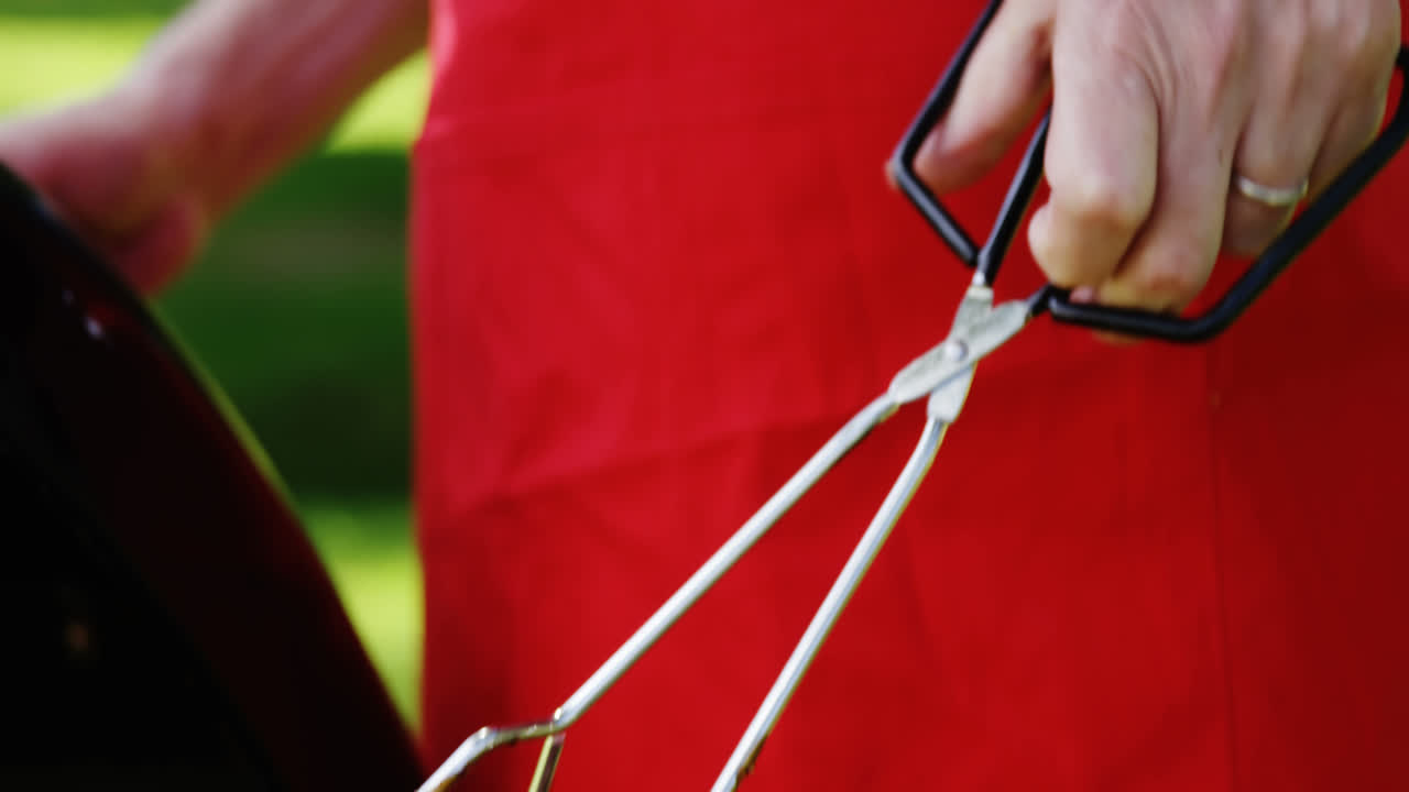 공원 에서 바베큐 에서 음식 을 준비 하는 고위 인사