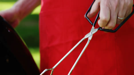 senior man preparing food on barbecue in the park